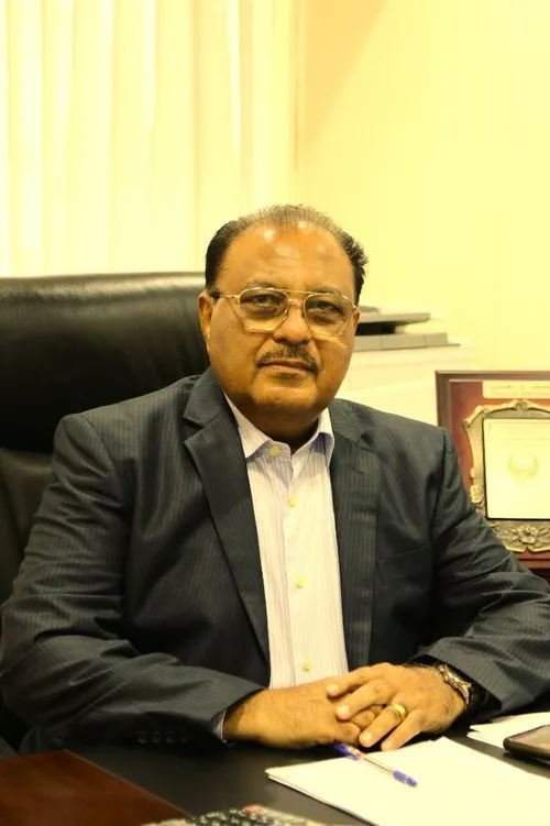 A man sitting at a desk in an office, focused on his work with determination and professionalism.