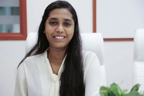 A woman in a white shirt sitting at a desk in an office.