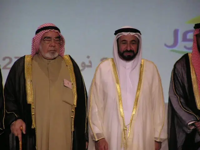 Three men in traditional clothing standing together, showcasing their cultural heritage and unity.