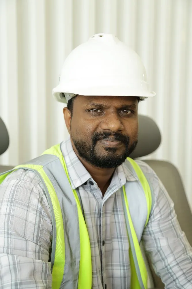 A man wearing a hard hat and vest, ready to work.